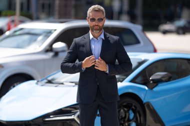 Lüks bir arabanın yanında zengin bir işadamı. Zengin bir iş adamı. Zarif zengin iş adamı. Pahalı arabası olan bir avukat. Premium arabada duran zengin bir işadamı. İş başarısı. Zenginlik kavramı