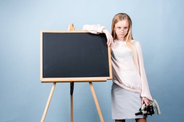 Tahtanın yanındaki kız öğrenci. Okul ve öğrenciler sınıfta. Eğitimli çocuklar. Okul sınıfındaki çocuk öğrenci. Öğrenim ve öğrenim kavramı