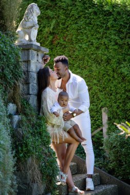 Çok ırklı ebeveynler ve karışık ırk bebekleri. Çok ırklı aile portresi. Mutlu çoklu etnik çiftler ve çocuk öpüşmeleri. Çok güzel bir aile. Çok ırklı bir aile birlikte eğlenir.