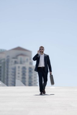 Zengin bir iş adamı dışarıda yürüyor. Çantası olan başarılı bir iş adamı. Lider harekete geçti. İş adamı güvenle yürüyor. Takım elbiseli bir iş adamı işe gidiyor. İş profesyoneli hareket halinde