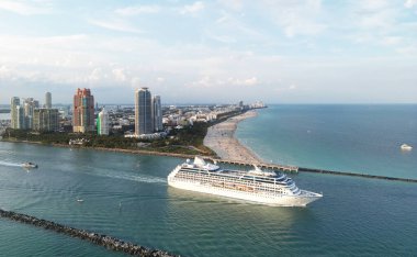 Lüks yolcu gemisi Miamis kıyısı yakınlarında yelken açıyor. Miami Beach 'te yolcu gemisi. Miami 'de yolcu gemisi olan bir Skyline. Gemi gezisi. Miami gemisinde tropik bir tatil. Miamis Rıhtımı
