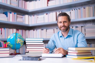 Öğretmenler günü. Okul sınıfında öğretmen öğretmeni. Bilgi, eğitim. Sınıfta ders veren bir adam. Üniversite sınavı. Üniversitede ders veriyorum. Eğitimci öğrenme kursları. Edebiyat okuyorum.