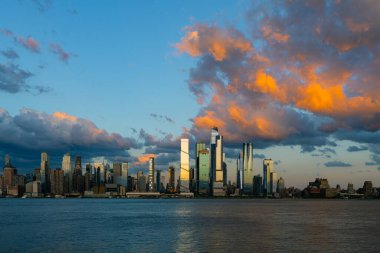 New York şehri. New York şehir manzarası. New York 'taki Lower Manhattan ve One World Trade Center. Manhattan 'ın gökdelenleri New York körfezinin dalgalanan sularının yanında mavi gökyüzüne karşı. New York gökdelenleri