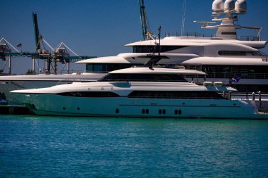 Deniz sularında yelken açmak. Denizde lüks bir yat. Yatları olan Miami Plajı. Yelkenli tropik deniz manzarası. Sahil şeridine yakın bir gemi turu. Florida 'da gün batımı yat yolculuğu. Okyanusta yat