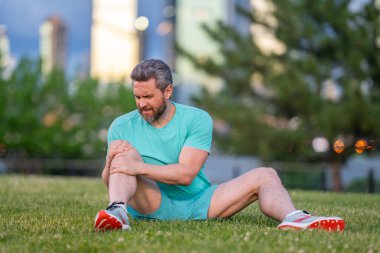 Antrenmandan sonra dizim kırıldı. Koşu sırasında bacağım ağrıyor. Dizini tutan yaralı bir adam. Koştuktan sonra bacakları ağrıyor. Dizinden yaralanan bir adam. Antrenman bacak ağrısı. Koşu diz travmasına yol açıyor. Bacak ağrısı.