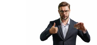 Gri arka planda kredi kartı olan bir adamın stüdyo portresi. Para yönetimi ve kredi puanı. Ödül programları. Kredi limiti. Başlık için afiş, kopyalama alanı. Web tasarımı için poster