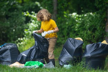 Çocuk dışarıda plastik şişe topluyor. Çevreyi koru ve atık kavramını azalt. Geri dönüşüm atıkları, çöp çöpleri, çöpler temizlenecek. Ekoloji konsepti. Çevre plastik kirliliği