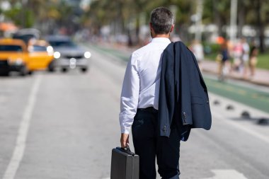 İşadamı işe yürüyerek gider. Hispanik iş adamı sokakta güven içinde yürüyor. Ofis çalışanı işe gidiyor. Olgun bir iş adamı şehirde yürüyor. Dışarıda yürüyen bir iş adamı. İş biçimi