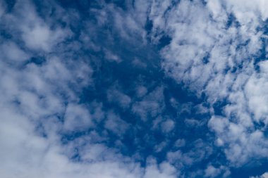 Yukarıdaki rüya gibi bulutlu manzara. Beyaz bulutlu gökyüzü. Gökyüzü arkaplan tasarımı Dolu bulutlar. Kabarık kümülüs bulutları sürükleniyor. Bulutlarda ışık ve gölge. Açık bulutlu gökyüzü ve temiz hava. Ufuk üzerinde sakin bir gökyüzü