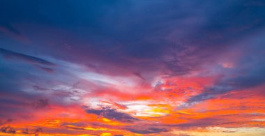 Gün doğumunda gökyüzü. Günbatımı arka planı. Gökyüzündeki bulutların arasından gün doğumu. Gündoğumu renkleriyle alacakaranlık gökyüzü. Yumuşak ışıkla huzurlu bir şafak. Bulutlu dramatik günbatımı. Açık gökyüzünde gün ışığı