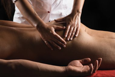 Spor masajı. Fizyoterapist, kaslı erkek atelete boyun ve omuz masajı yapıyor. Fizyoterapist erkek skapula trapezius 'a masaj yapıyor.