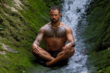 Meditasyon. Doğada uyum ve huzur. Sakin bir sporcu çevrede meditasyon yapıyor. Farkındalık. Doğada rahat bir adam. Özgürlük ve mutluluk. Dışarıda yoga yapan kaslı, fit bir adam.