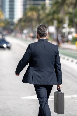 İşadamı işe yürüyerek gider. Hispanik iş adamı sokakta güven içinde yürüyor. Ofis çalışanı işe gidiyor. Olgun bir iş adamı şehirde yürüyor. Dışarıda yürüyen bir iş adamı. İş biçimi