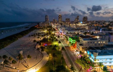 Miami şehir merkezinin gece lambasında manzarası. Güney Sahili 'ndeki tropik cennet. Miami 'de gece yarısı ışıkları. Miami ufuk çizgisinin rıhtım manzarası. Gün doğumunda Miami 'nin hava görüntüsü. Neon Art Deco. Okyanus