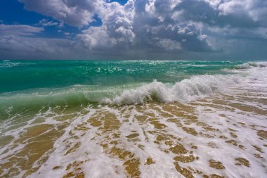 Deniz kıyısında dalga hareketi. Yaz okyanus esintisi. Deniz doğası arka planı. Huzurlu okyanus. Rüya gibi okyanus ufku. Kıyı okyanusu cennet duvar kâğıdı. Deniz köpüğü dalgaları. Gök mavisi su yüzeyi. Altın saat kumsalı