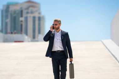 Zengin iş adamı dışarıda dolaşıyor. Çantası olan başarılı bir iş adamı. Lider harekete geçti. İş adamı güvenle yürüyor. Takım elbiseli bir iş adamı işe gidiyor. İş adamı profesyonel hareket halinde