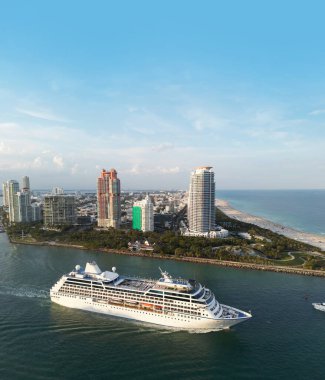 Lüks yolcu gemisi Miamis kıyısı yakınlarında yelken açıyor. Miami Beach 'te yolcu gemisi. Miami 'de yolcu gemisi olan bir Skyline. Gemi gezisi. Miami gemisinde tropik bir tatil. Miamis Rıhtımı