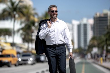 İş adamı işe yürüyerek gider. Hispanik iş adamı sokakta güven içinde yürüyor. Ofis çalışanı ofise gidiyor. Olgun bir iş adamı şehirde yürüyor. Dışarıda yürüyen bir iş adamı. İş biçimi