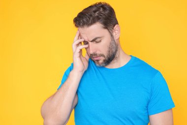 Başı ağrıyan bir adam, stüdyo portresi. Yorgun adamın başı ağrıyor. Bitkin, sağlıksız hisseden, baş ağrısı hastalığına üzülen bir adam. Migren ve baş ağrısı konsepti. Migren.