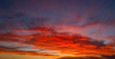 Gün batımında gökyüzü. Ufukta gün doğumu. Gökyüzündeki bulutların arasından gün batımı. Günbatımı renklerinde alacakaranlık gökyüzü. Yumuşak ışıkla huzurlu bir şafak. Bulutlu dramatik alacakaranlık. Açık gökyüzünde gün ışığı