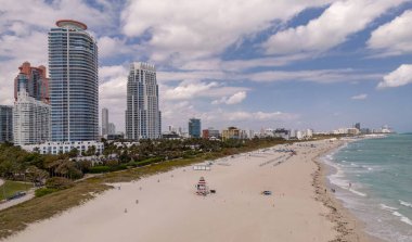 Miami 'de kumsalda güneşli yataklı, okyanus dalgalı bir plaj. Muhteşem manzaralı Miami Beach cenneti. Güney Sahili Miami cankurtaranı. Miami 'de huzurlu bir deniz kenarı inzivası. Kıyı gevşemesi