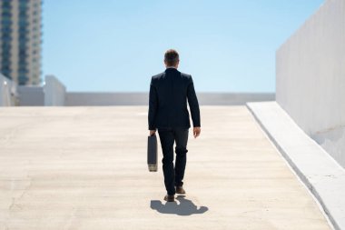 Evrak çantasıyla yürüyen bir iş adamı. İşadamı çekip gidiyor. Şirket lideri git buradan. Çantalı takım elbiseli adam. Profesyonel bir iş adamı. Kentsel iş adamı