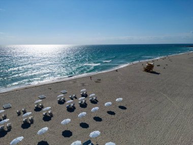 Okyanus dalgalarıyla kumlu bir sahilde güneşlenmek. Yaz güneşinin altında huzurlu bir deniz kenarı inzivası. Huzurlu denize bakan dinlenme yerleri. Muhteşem manzaralı Miami Beach cenneti. Kıyı gevşemesi