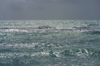 Deniz dalgaları arka planı. Yaz turizmi. Okyanus suyu hareketi. Okyanus sıçrama dalgası arka planı. Derin mavi deniz plajı. Turkuaz dalga. Rüya gibi egzotik deniz plajı. Güzel deniz dalgaları