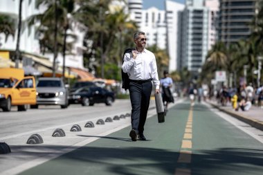 İş adamı işe yürüyerek gider. Hispanik iş adamı sokakta güven içinde yürüyor. Ofis çalışanı ofise gidiyor. Olgun bir iş adamı şehirde yürüyor. Dışarıda yürüyen bir iş adamı. İş biçimi