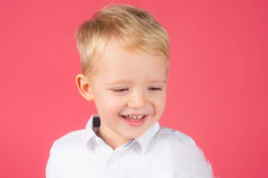 Gülümseyen güzel bir çocuğun portresi. Neşeli bir yüzü olan mutlu bir bebek. Yakın planda sevimli bebek yüzü. Neşeli bir gülümsemesi olan masum bir erkek bebek. Mutlu çocukluk portresi. Tatlı çocuk suratı.