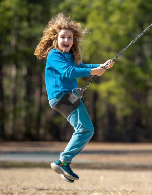 Çocuk salıncakta eğleniyor. Çocuk bahçesinde mutlu bir çocuk. Kaygısız çocuk dışarıda sallanıyor. Mutlu çocuklar dışarıda oynuyor. Sarışın çocuk heyecandan titriyor. Dışarıdaki oyuncu çocuk. Eğlenceli çocuk suratı