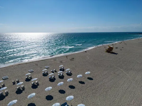 Okyanus dalgalarıyla kumlu bir sahilde güneşlenmek. Yaz güneşinin altında huzurlu bir deniz kenarı inzivası. Huzurlu denize bakan dinlenme yerleri. Muhteşem manzaralı Miami Beach cenneti. Kıyı gevşemesi
