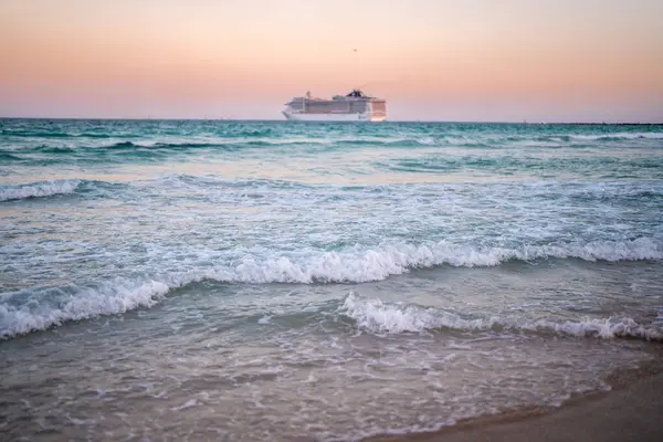Okyanusta bir gemi turu. Günbatımında lüks bir yolcu gemisi. Yolcu gemisi olan Miami Plajı. Turkuaz su ve yolcu gemisi. Kıyıya yakın bir turist gemisi. Okyanus dalgaları ve gemi teknesi