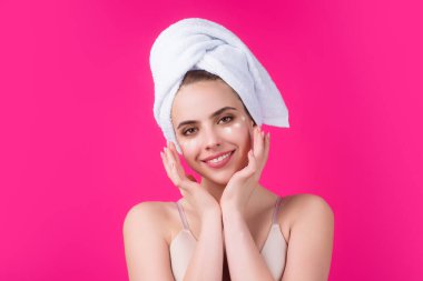 Yüzüne krem süren genç bir kadın. Cilt bakımı ve kozmetik konsepti. Cilt bakımı. Stüdyo geçmişine krem süren bir kız. Cilt nemlendirici