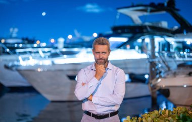 Yatın yanındaki zengin iş adamı. Lüks yatın keyfini çıkaran zengin bir adam. Milyoner ya da milyarder yaşam tarzı. Özel bir yatta zengin bir adam. Finansal özgürlük. Başarılı bir işadamının olduğu pahalı bir yat.