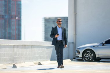 Başarılı bir iş adamı telefonu açık havada tutar. İş adamı dışarıda telefonla konuşuyor. Takım elbiseli olgun iş adamı. Şirket işi. Takım elbiseli zengin iş adamı. Açık hava iş portresi