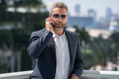 İş adamı kendinden emin duruyor. Başarılı bir iş adamı. Takım elbiseli bir yönetici. Yakışıklı iş adamı kendinden emin görünüyor. Şehir ortamında Orta Doğulu bir iş adamı. Ofis yakınlarında olgun bir işadamı