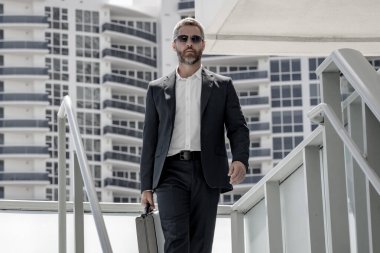 Ofis binasının dışında yürüyen bir iş adamı. İş adamı şehre işe yürüyerek gider. Dışarıda dolaşan takım elbiseli bir yönetici. Ofis çalışanı kendine güvenerek yürüyor. Tarz sahibi iş adamı geçiyor.