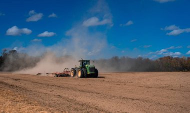 Traktör tarlada toprak sürüyor. Toprak üzerinde çiftçilik. Kırsal tarım arazilerinde traktör. Toprakta çalışan tarım makinesi ya da traktör. Çekici tarla sürme çiftliği. Çiftlik arazisi