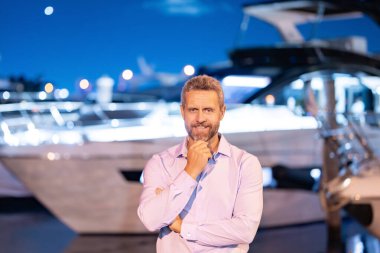 Yatın yanındaki zengin iş adamı. Zengin zengin bir adam lüks hayat tarzını seviyor. Özel bir yatta zengin bir adam. Finansal özgürlük. Başarılı ve zengin bir işadamının olduğu pahalı bir yat.