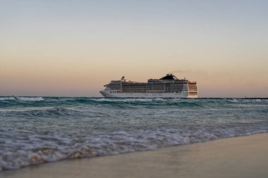 Okyanusta bir gemi turu. Günbatımında lüks bir yolcu gemisi. Yolcu gemisi olan Miami Plajı. Turkuaz su ve yolcu gemisi. Kıyıya yakın bir turist gemisi. Okyanus dalgaları ve gemi teknesi