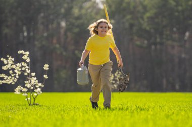 Bahçeye ağaç dikmiş bir çocuk. Çocuk kürekle toprak kazıyor ve ağaç dikiyor. Çocuk bahçıvan meyve ağacıyla ilgileniyor. Çocuklarla ağaç dikmek. Yeşillik için ağaç diken çocuk. Çocuklar için bahçe.