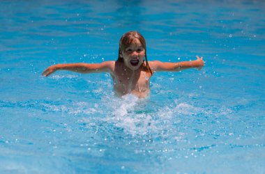Çocuk yaz tatilinin tadını çıkarıyor, havuzda yüzüyor. Çocuk yaz tatilinde bilardoda eğleniyor. Havuz suyunda oynayan mutlu çocuklar. Mutlu yazlar. Yaz tatilindeki çocuk suda oynar