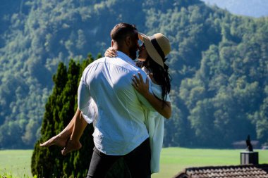 Seksi çift tutkuyla doğayı kucakladı. Şehvetli bir çift yazın şefkatle sarılır. Aşık çift, güneşin öptüğü çayırda öpüştü.