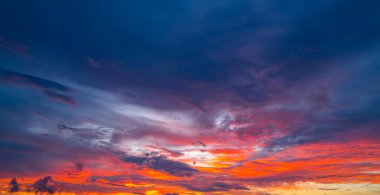 Gün batımında gökyüzü. Gündoğumu arka planı. Gökyüzündeki bulutların arasından gün batımı. Günbatımı renklerinde alacakaranlık gökyüzü. Yumuşak ışıkla huzurlu bir şafak. Bulutlu dramatik alacakaranlık. Açık gökyüzünde gün ışığı