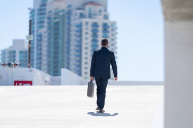 Evrak çantasıyla yürüyen bir iş adamı. İşadamı çekip gidiyor. Şirket lideri git buradan. Çantalı takım elbiseli adam. Profesyonel bir iş adamı. Kentsel iş adamı işe gidiyor.