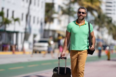 Yalnız seyahat etmek. O, şehirde seyahat etmeye başlarken, o yaz tropikal caddede bir turist. Yaz gezisi. Seyahat seyahati. Yaz, seyahat için mükemmel bir zamandır. Seyahat eden insanlar