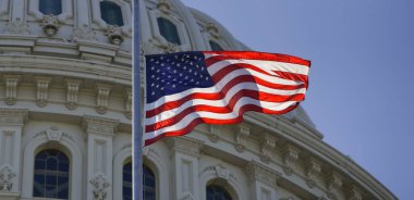 Birleşik Devletler bayrağı Kongre Binası 'nın üzerinde dalgalanıyor. Bayraklı hükümet binaları. Kongre Binası, Amerikan bayrağının yanında. Kongre. Amerikan bayrağı dalgalanıyor. Washington, DC 'deki Capitol Hill.