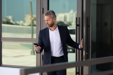 İş adamı bir ofis binasına giriyor. Yetişkin bir iş adamı toplantıya giriyor. Ofis kapısından giren bir iş adamı. Karizmatik iş adamı kapıdan giriyor. İş anlaşması