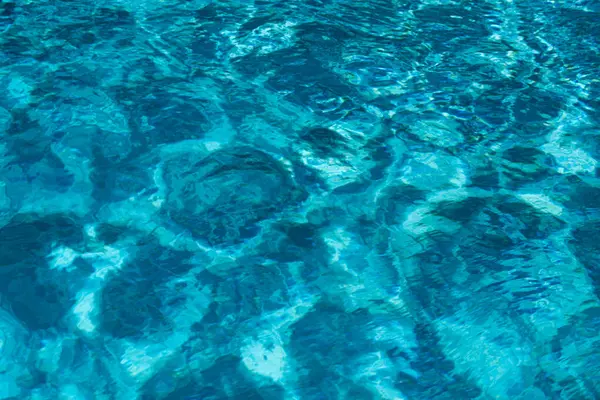 Yüzme havuzunda yırtık su. Mavi yüzme havuzunun yüzeyi, suyun arka planı